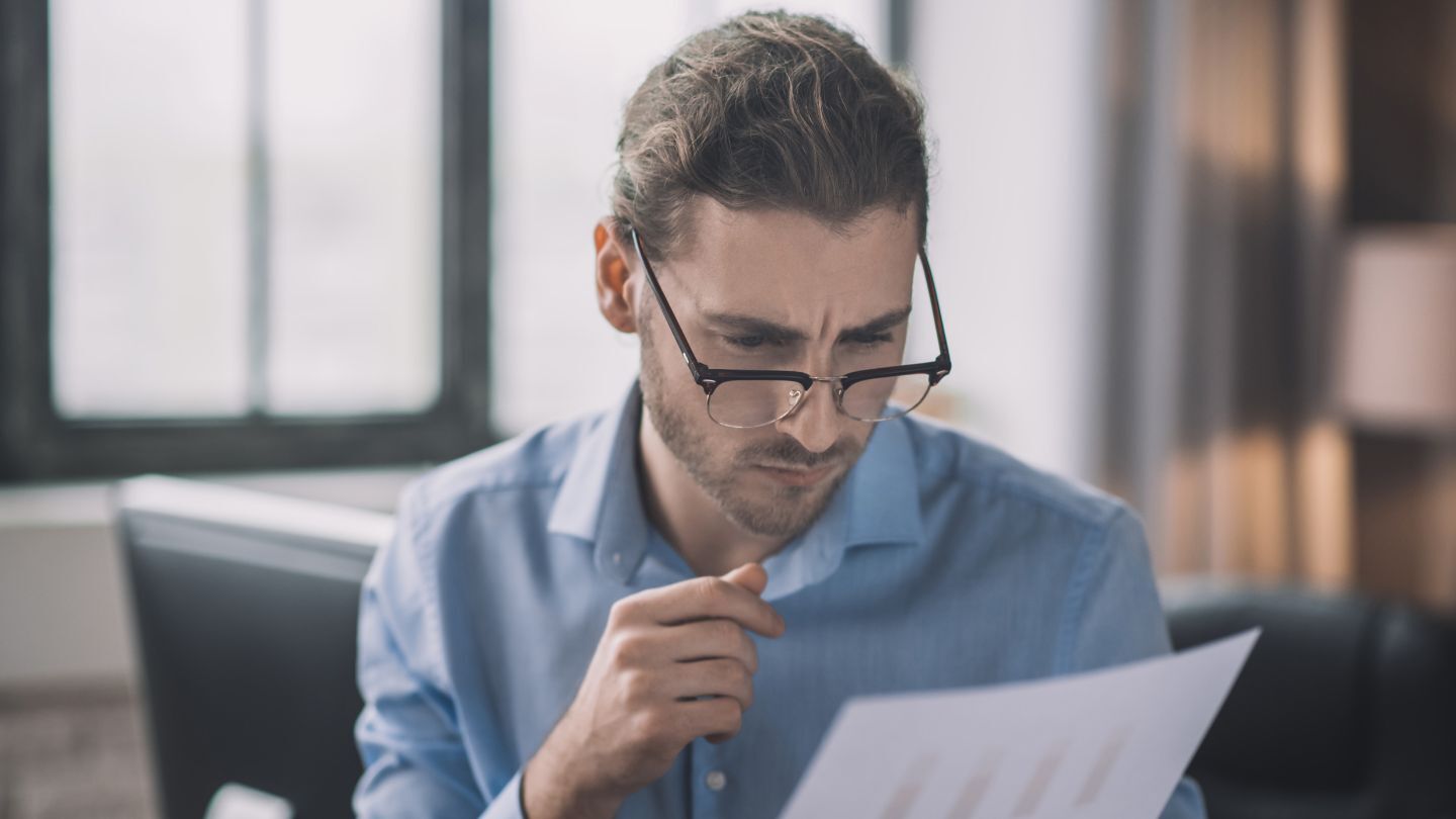 Crédito de consumo. Hombre con lentes leyendo un documento