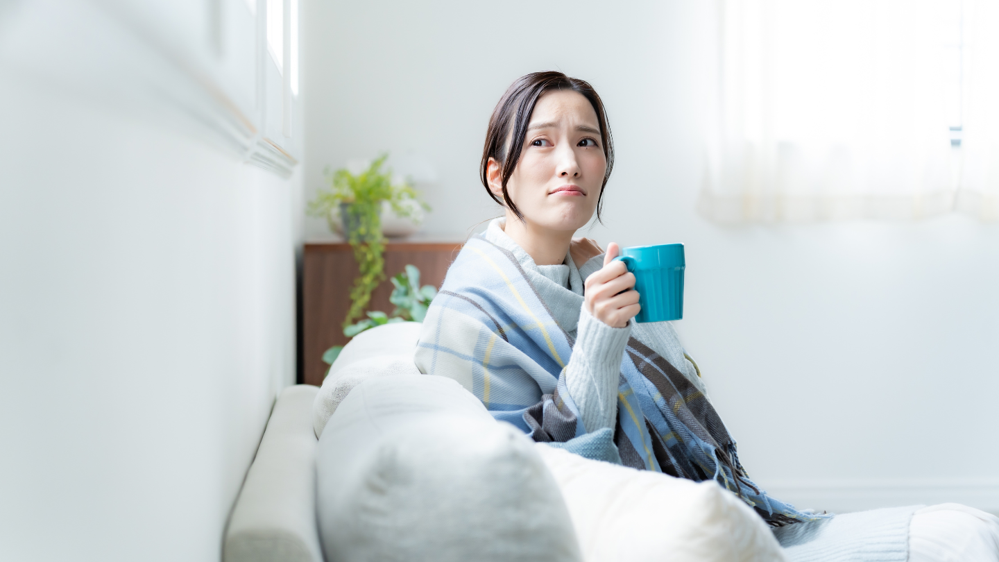 DefensaDeudores.cl. Receptor judicial. Mujer sentada en el sofá, tomando té, con cara de preocupada