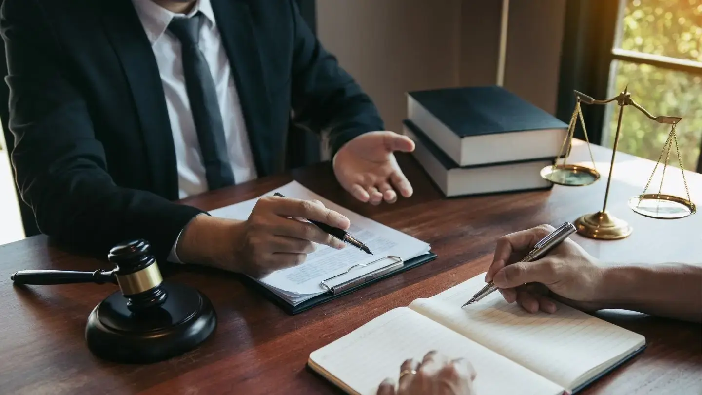 Juicio ejecutivo: plazos, excepciones y defensa. Dos hombres revisan y redactan documentos