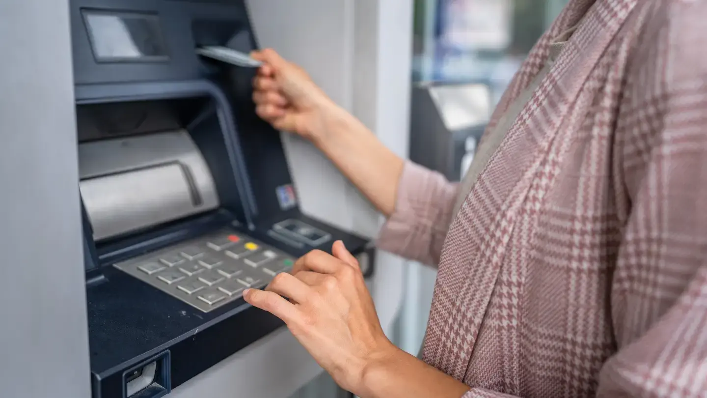 Qué pasa si no pago un avance en efectivo. Mujer usando cajero automático