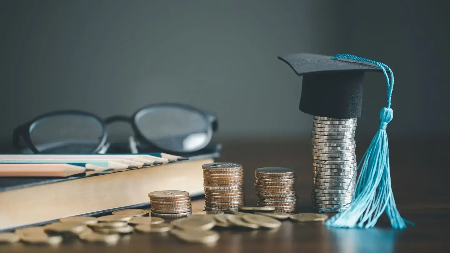 Embargo por deuda CAE. Lentes, libro, monedas y gorro universitario
