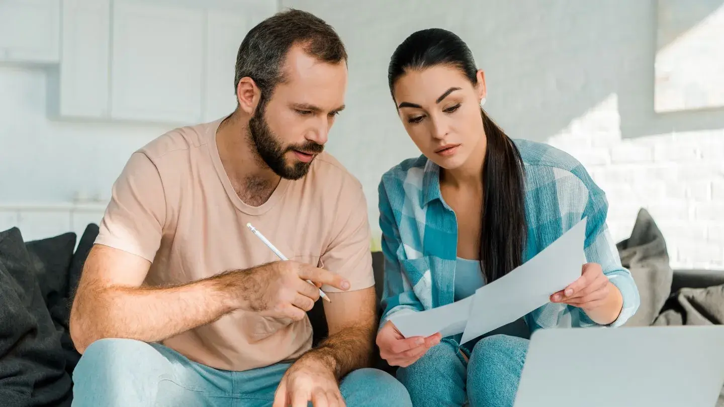 Codeudor solidario. Pareja de hombre y mujer adultos conversando de un documento