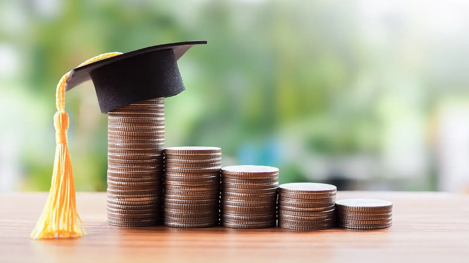 Qué pasa si no pago el Fondo Solidario. Gorro universitario sobre monedas apiladas