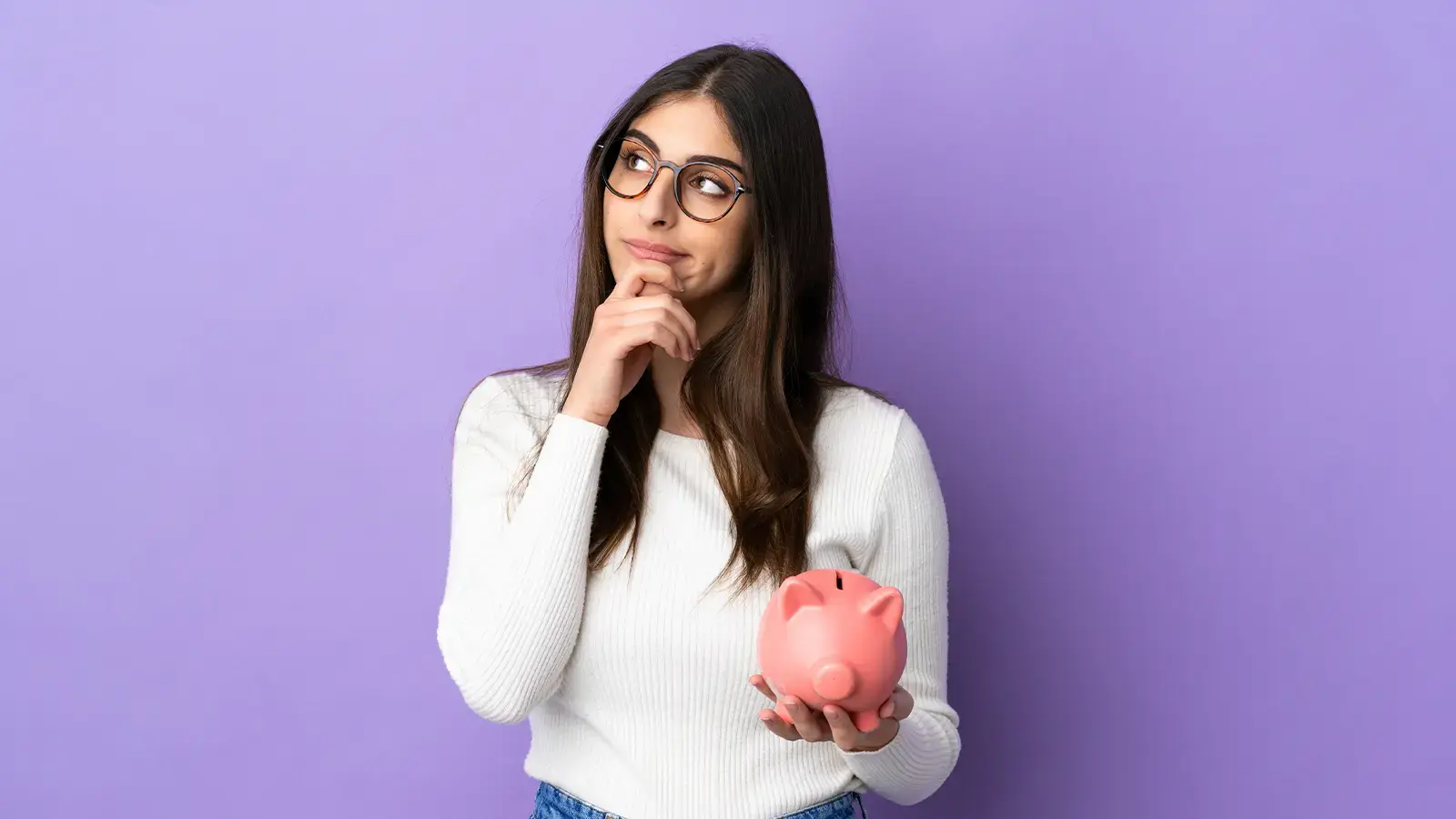 Quiebra personal. Mujer pensando con una alcancía en la mano