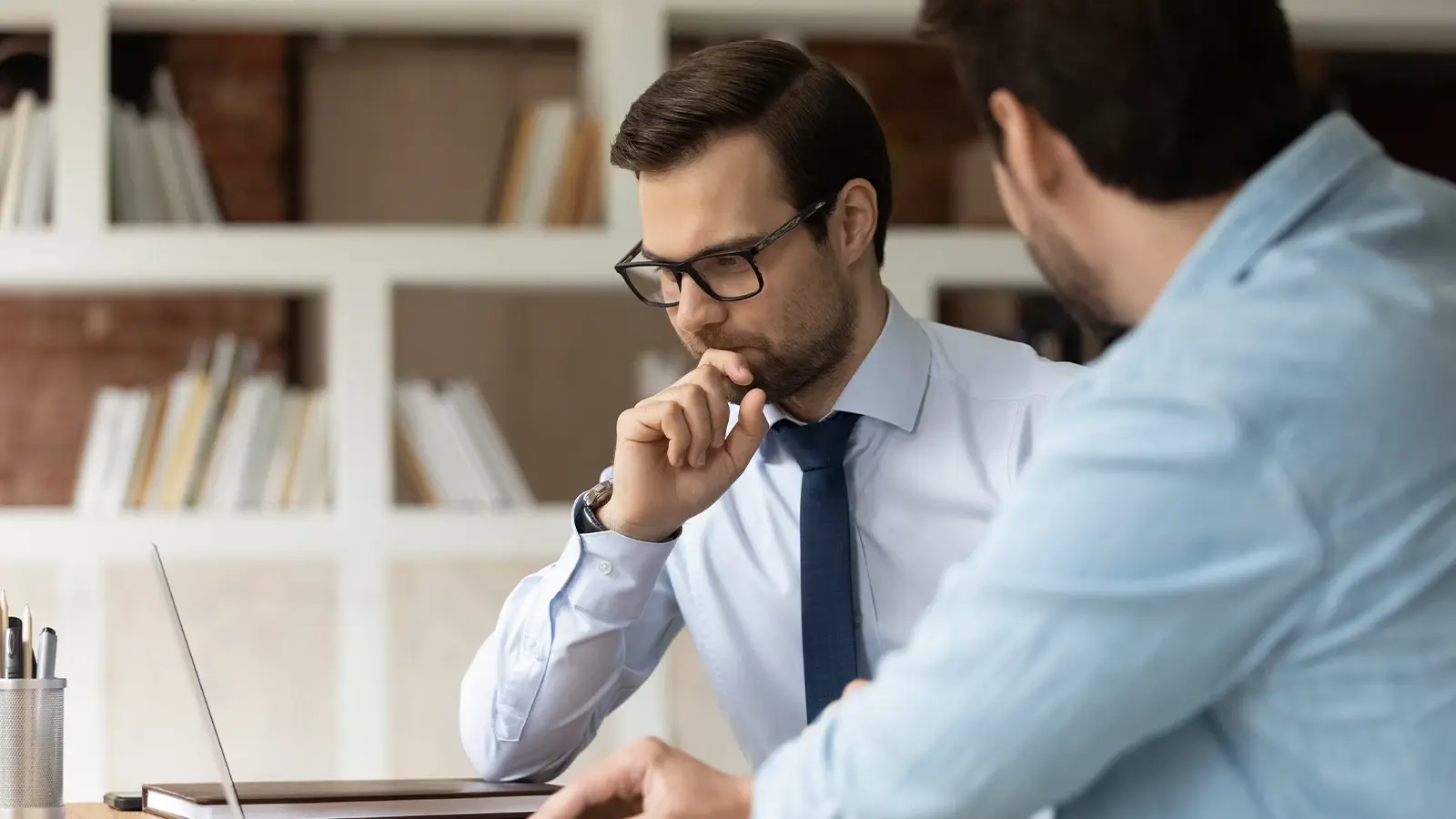 Riesgos y consecuencias de reorganizar una empresa. Joven empresario nervioso hablando con socio